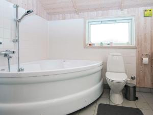 a white bathroom with a tub and a toilet at 8 person holiday home in Harboøre-By Traum in Harboør