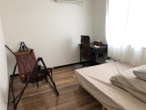 a bedroom with a bed and a chair and a desk at Guesthouse & Kitchen Hace - Vacation STAY 68911v in Iwaki
