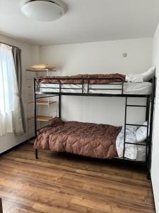 a bedroom with two bunk beds and a wooden floor at Guesthouse & Kitchen Hace - Vacation STAY 68911v in Iwaki