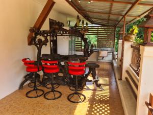 a room with a bar with red stools at Sawaddee Holland in Ban Phlong Takhe
