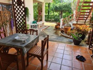 a table and chairs on a patio with plants at Sawaddee Holland in Ban Phlong Takhe +21 photos