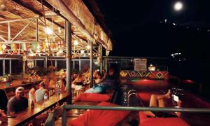 a group of people sitting on a boat at night at Outpost Hostel - Coron in Coron