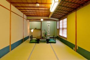 um quarto com uma mesa e cadeiras e paredes amarelas em Mitsuki Kyoto em Quioto