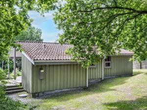 a green building with a yard at 6 person holiday home in Hadsund-By Traum in Øster Hurup