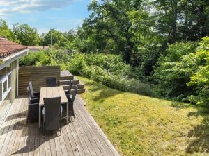 a wooden deck with a table and chairs on it at 6 person holiday home in Hadsund-By Traum in Øster Hurup
