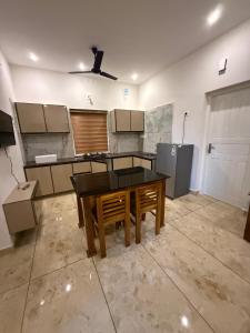 a kitchen with a table in the middle of a room at Sahara Homes in Ernakulam