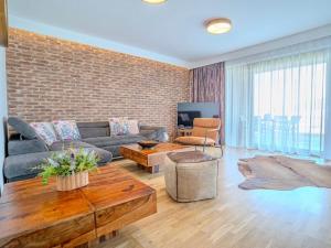 a living room with a couch and a table at Vysoké Tatry - ISC RESORT in Mlynica