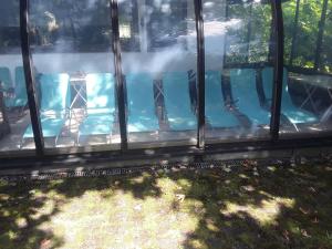 a swimming pool with blue chairs in a house at Pension Waldeck Fleckl in Warmensteinach