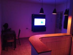 a purple room with a tv and a table at kit net Vovó nice garagem gratis in Aparecida
