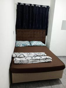 a bedroom with a bed with a headboard at kit net Vovó nice garagem gratis in Aparecida