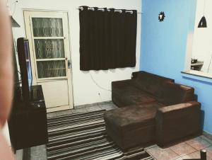 a living room with a couch and a door at kit net Vovó nice garagem gratis in Aparecida +13 photos