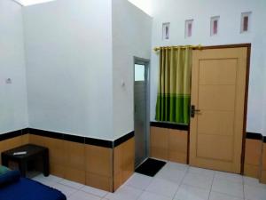 a room with a door and a green curtain at Al Kiswah homestay in Lombok International Airport