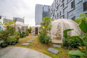 a garden with a greenhouse and some plants and buildings at F-TOWN Fangtang Hotel (Shenzhen Longgang Tian'an Digital City Huanggekeng Subway Station) in Qinglinjing