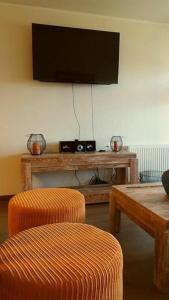 a living room with two chairs and a television on a wall at Departamento Costa Pucon in Pucón