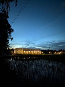 a building at night with a field of grass at Mangrove Forest Camp Eco Stay Sundarbans, India in Jāmb