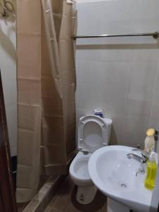 a bathroom with a white toilet and a sink at JeoLola in Ankuru