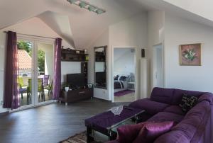 een woonkamer met een paarse bank en een tv bij Apartments Laledo in Dubrovnik