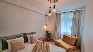 Un dormitorio con una cama, una silla y una ventana en Cozy Tartu Apple Garden with Terrace, en Tartu