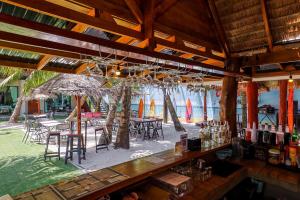 un bar con tavoli, sedie e ombrelloni sulla spiaggia di คินโจ พาร์ค รีสอร์ต - ใกล้วัดเจดีย์ ไอ้ไข่ ad Amphoe Sichon