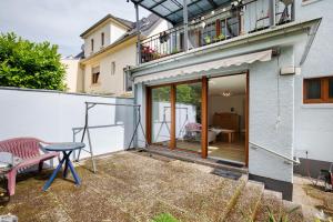 un pequeño patio con mesa y balcón en Ferienwohnung mit Garten, en Andernach