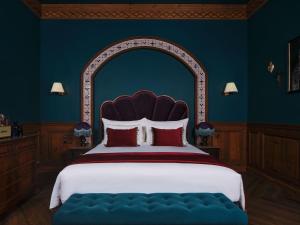 a bedroom with a large bed with a blue wall at Maison Mystique Khao Yai in Mu Si