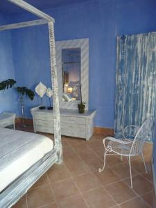 アグリジェントにあるVilla Mare Di Montelusaのベッドルーム1室(ベッド1台、椅子、鏡付)