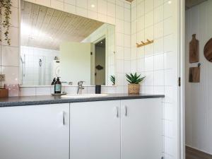 ein weißes Badezimmer mit Waschbecken und Spiegel in der Unterkunft 6 person holiday home in Tarm-By Traum in Tarm