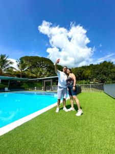 a man and a woman standing next to a swimming pool at Alojamiento Rural San José in Cartago