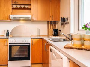 a kitchen with wooden cabinets and a stove top oven at 8 person holiday home in Odder in Odder +46 photos