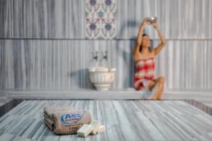 a woman sitting on a bed in a bathroom at Aes Club Hotel in Oludeniz