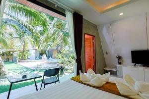 una camera da letto con un letto e una grande finestra di คินโจ พาร์ค รีสอร์ต - ใกล้วัดเจดีย์ ไอ้ไข่ ad Amphoe Sichon