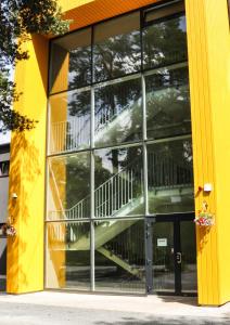 een geel gebouw met een trap in het raam bij Männiku JK in Tallinn