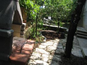 a bench sitting next to a tree in a garden at Apartment Sea Garden in Ičići
