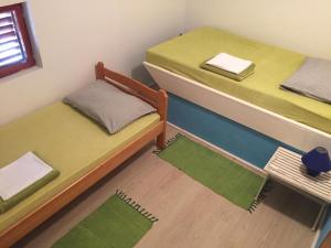 two beds in a room with green mats on the floor at Apartments Pavić in Betina