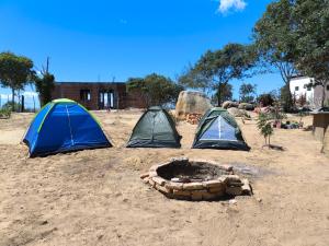 three tents and a fire pit in the sand at Ecocamping Okaeté in Buíque