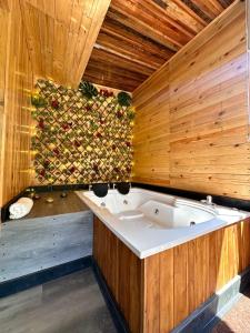 a bath tub in a room with a wooden wall at Alojamiento Rural San José in Cartago