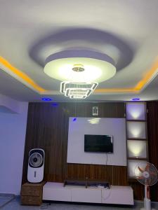 a room with a ceiling with a television and a light at Cee&Tee at AKOBO 1Bedroom or 2Bedrooms -247 Electricity-Solar Inverter AC in Bedrooms in Ibadan