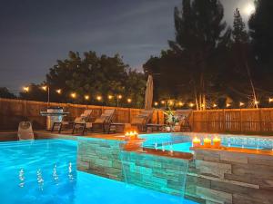 una piscina con luces en un patio trasero por la noche en Fox Garden Luxury Boho Near Downtown & Beach home, en Fort Lauderdale