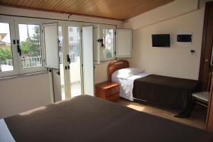 a small bedroom with two beds and a window at B&B MeriGio' in Villapiana