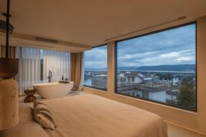a bedroom with a tub and a large window with a view at DaLi牧云相框空间侘寂民宿 in Dali Ancient Town