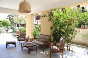 a patio with chairs and tables and a bush with red flowers at B&B MeriGio' in Villapiana