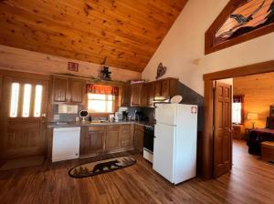 a kitchen with a white refrigerator and wooden cabinets at Perfectlocation,PerfectviewsforTwo,Indoor Jacuzzi,hottub,FreeticketstoDollywood,Anakeesta,&More in Gatlinburg