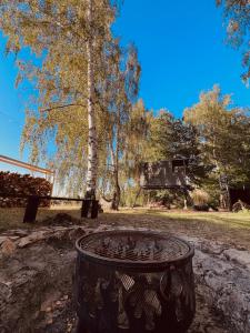 a trash can in front of a tree and a house at Ostrov klidu - posed - sauna 