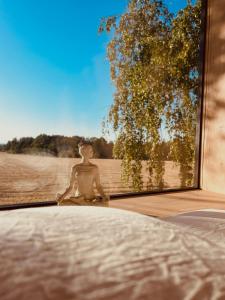 a statue of a person sitting in a window at Ostrov klidu - posed - sauna in Hradešín
