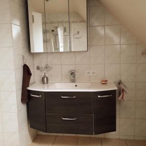 a bathroom with a sink and a mirror at Ferienhaus Brit in Albstadt +29 photos