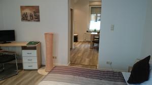 a bedroom with a bed and a desk with a computer at Appartment am Nordpark in Mönchengladbach
