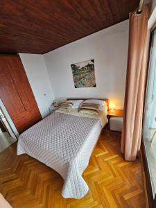 a bedroom with a white bed with a wooden floor at Rooms BELA in Ičići +58 photos