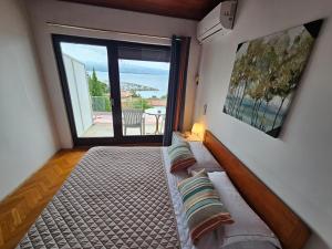 a bedroom with a bed and a large window at " Rooms Bela" balcony in Ičići +40 photos