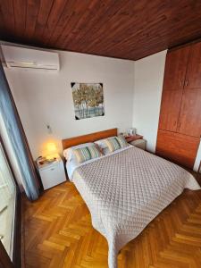 a bedroom with a bed and a wooden ceiling at " Rooms Bela" balcony in Ičići