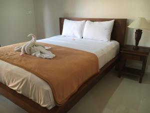 Una cama con un animal de peluche encima. en Gedong Bali Family Homestay en Ubud
